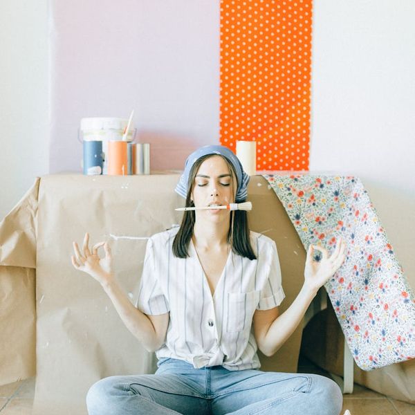 Person meditating calmly in a bright, minimalist room.